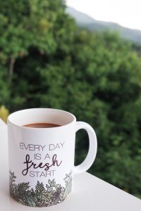 Coffee mug with a scenic mountain background.